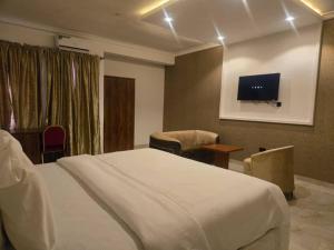 a bedroom with a bed and a tv on the wall at ROSES REGENCY HOTEL AND SUITES in Abuja