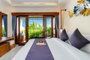 a bedroom with a bed with a cake on it at Svadarma Bali Villa by Dhananjaya Hospitality in Darmasaba +76 photos