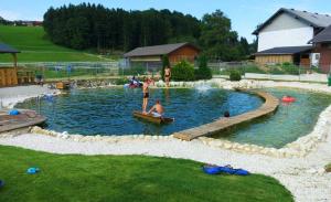 basen dla dzieci z ludźmi bawiącymi się w wodzie w obiekcie Kinderparadies Bachbauer w mieście Mondsee