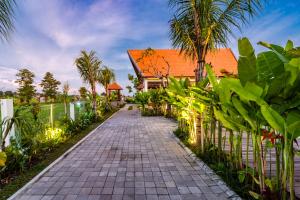 a walkway in front of a house with a fence at Svadarma Bali Villa by Dhananjaya Hospitality in Darmasaba