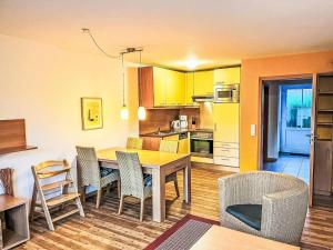 a kitchen and dining room with a table and chairs at Ferienhaus Seepark 104 in Hoddersdeich