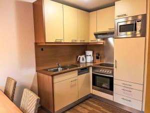 a small kitchen with a sink and a microwave at Ferienhaus Seepark 104 in Hoddersdeich +2 photos