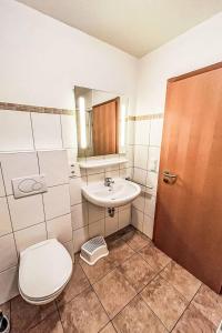 a bathroom with a toilet and a sink at Ferienhaus Seepark 104 in Hoddersdeich