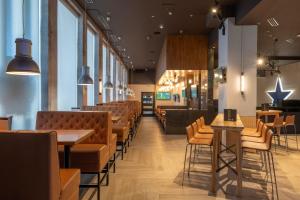a restaurant with chairs and tables and a bar at Sandman Signature Newcastle Hotel in Newcastle upon Tyne