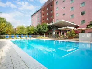 a large swimming pool in front of a hotel at Novotel Brescia Due in Brescia