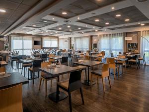 a dining room filled with tables and chairs at Novotel Brescia Due in Brescia