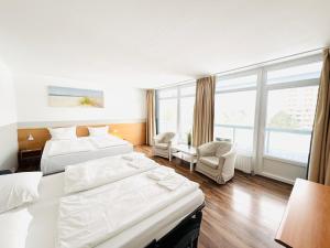 a hotel room with two beds and a window at Hotel Plöner See by Tulip Inn in Plön