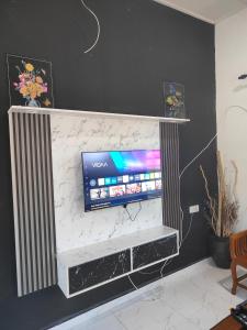a flat screen tv sitting on top of a wall at Penarik baru homestay in Kampung Penarik