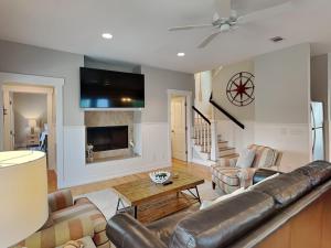 a living room with a leather couch and a table at Billfish in Tybee Island