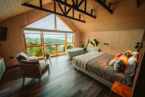 a bedroom with a bed and a tub and a window at Tungulú - Hotel Boutique & Cabañas in Puerto Montt