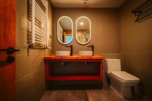 a bathroom with a sink and a toilet and mirrors at Tungulú - Hotel Boutique & Cabañas in Puerto Montt +44 photos