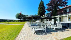a patio with tables and umbrellas in front of a building at Svostrup Kro in Silkeborg