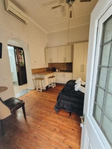 a bedroom with a bed and a kitchen with a table at Skinkikofi Guest House in Paarl