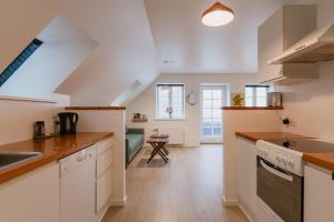 eine Küche mit weißen Schränken und einer Spüle in der Unterkunft Aroma Guesthouse in Ærøskøbing + 18 Fotos