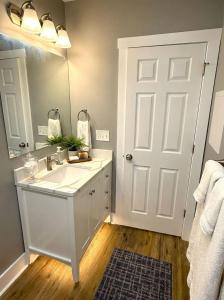 a white bathroom with a sink and a mirror at Cozy unit King bed & laundry in Wilmington