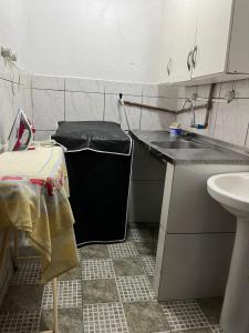 a small kitchen with a sink and a trash can at Espaço Ideal 7 in Cascavel