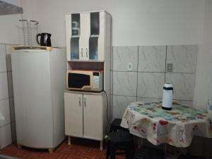a small kitchen with a table and a microwave at Espaço Ideal 7 in Cascavel
