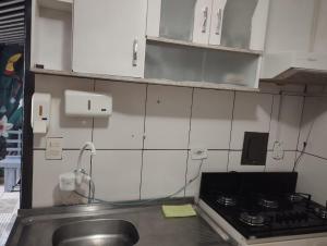 a kitchen with a sink and a stove at Espaço Ideal 7 in Cascavel