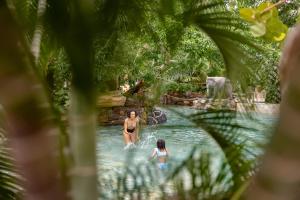 two people swimming in a pool at a theme park at Center Parcs Apartments Erperheide in Peer