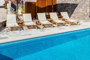 a group of chairs sitting next to a swimming pool at Apartment LaVilla in Mlini