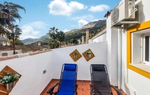 a balcony with two blue chairs on a white wall at La Escapadita in Benaoján +26 photos