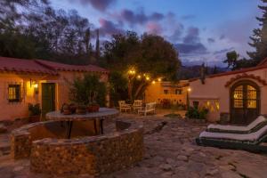 a patio with a table in a yard at night at Los Arcabuceros Casa Hotel Boutique in Tilcara