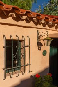 a building with a window with a lantern and a light at Los Arcabuceros Casa Hotel Boutique in Tilcara