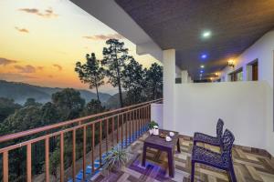 a balcony with two chairs and a table with a view at The Starlight Hotel Kasauli by Splendid Retreat Hotels in Kasauli