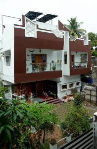 a white and brown house with a palm tree at Greeny Homestay in Cochin