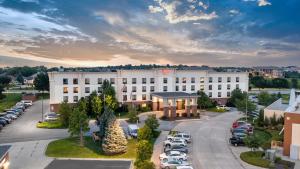 a large white building with cars parked in a parking lot at Newly Renovated Hampton Inn Omaha West Lakeside in Lane
