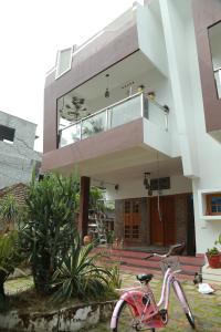 a pink bike parked in front of a building at Greeny Homestay in Cochin