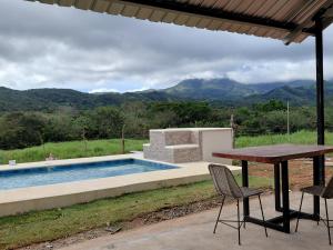 a table and chairs next to a swimming pool at Sansalo Lounge Capira in Lídice
