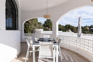 a dining room with a table and chairs on a balcony at Casa SD in Casas de Torrat