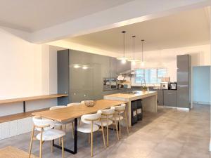 a large kitchen with a wooden table and chairs at Beachouse@Stilbaai in Stilbaai