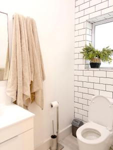 a white bathroom with a toilet and a window at Beachouse@Stilbaai in Stilbaai +24 photos