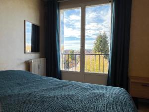 a bedroom with a bed and a large window at Lemoine in Châteauroux