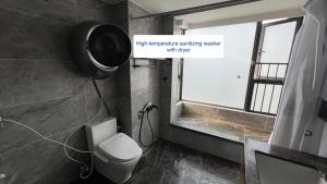 a bathroom with a white toilet and a window at Family-friendly apartment in Dongguan +8 photos