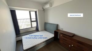 a small bedroom with a bed and a window at Family-friendly apartment in Dongguan