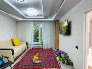 a child sitting on a rug in a living room at Davos in Ak-Bulun
