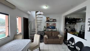a kitchen and a living room with a table and chairs at Casa Mirante da Sereia in Salvador