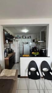 a kitchen with two black chairs in a kitchen at Casa Mirante da Sereia in Salvador