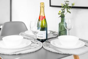 a table with white plates and a bottle of wine at Modern 2 Bed Apartment - Parking - Sleeps 3 - Netflix 27AC in Sleightholme +30 photos