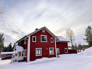 a red house with snow on the ground at Piteå Relax and Play Billiard Ap1 in Piteå