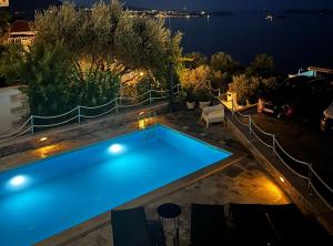a swimming pool with a view of the water at night at Apartment LaVilla in Mlini