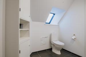 ein weißes Badezimmer mit Toilette und Fenster in der Unterkunft Aroma Guesthouse in Ærøskøbing