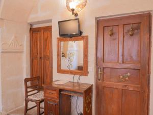 a room with a wooden door and a mirror and a table at Kismet Cave House in Göreme