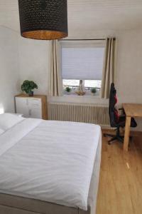 a bedroom with a bed and a desk and a window at Das Litzldorf in Sankt Michael im Lungau
