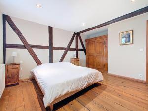 a bedroom with a white bed and wooden floors at Les Perles du Ried - Gîte 7 - 15mn Europapark - Proche Strasbourg Colmar in Boofzheim