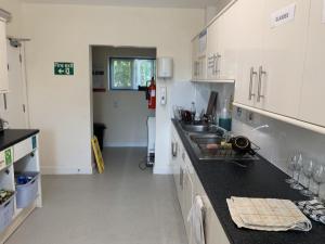 a kitchen with white cabinets and a black counter top at Stonehenge Farmhouse in Salisbury