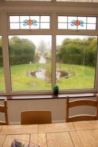 a room with two windows with a view of a pond at Stonehenge Farmhouse in Salisbury +26 photos